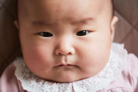 Close-up of Asian cute newborn baby looking at cameraの写真素材
