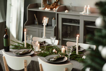 Background image of elegant dining table decorated for Christmas in minimal grey and silver tones, copy spaceの写真素材