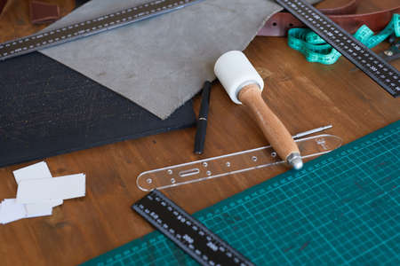 High angle background image of various tools and supplies on wooden table in tanners workshop, copy...