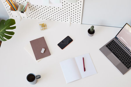 Top view background image of minimal white workplace with laptop and notebook, copy spaceの写真素材