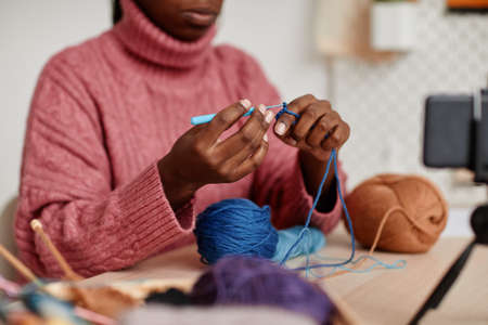 Close up of unrecognizable young African-American woman knitting at home, copy spaceの写真素材