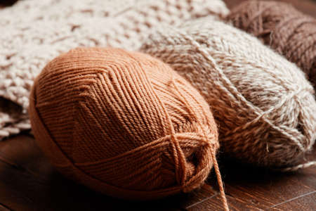 Close up of neutral colored wool on dark wooden background, knitting and hobby, copy spaceの写真素材