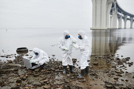 Group of people wearing hazmat suits collecting probes outdoors, toxic waste and pollution concept, copy spaceの写真素材