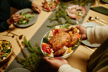 Top view close up of African-American woman bringing food to table while celebrating Thanksgiving with familyの写真素材