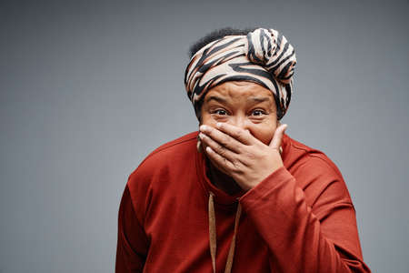 Waist up portrait of carefree black senior woman making surprised faces against white background, copy spaceの写真素材