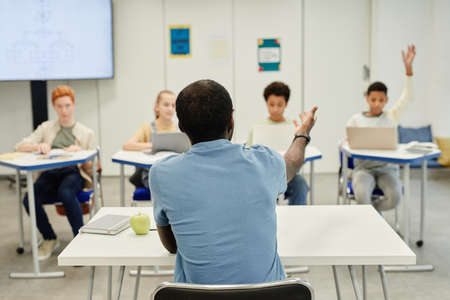 Back view shot of African-American teacher working with diverse group of children, copy spaceの写真素材