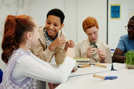 Diverse group of children experimenting in biology class, focus on smiling African-American girlの写真素材