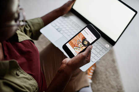 Close up of young African-American woman using smartphone with food delivery app, copy spaceの写真素材
