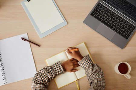Minimal top view of child doing homework at desk at home, copy space