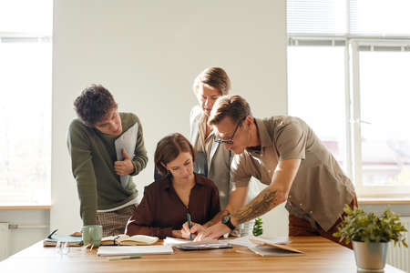 Minimal portrait of business team collaborating in office lit by sunlight, copy spaceの写真素材