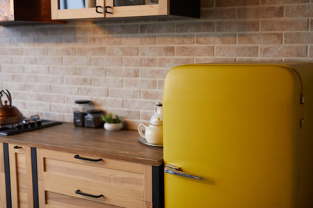 Background image of kitchen interior with brick wall and yellow retro fridge, copy space