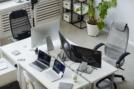Part of contemporary open space bureau of diversity programming with computer monitors and two...