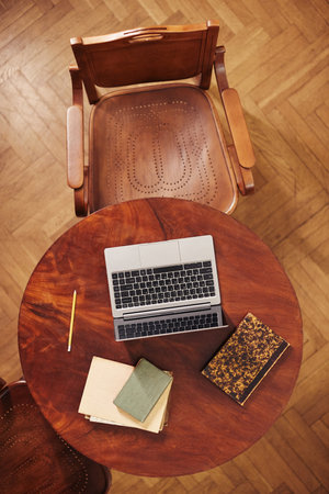 Vertical top view background of cozy working space with laptop in classic library