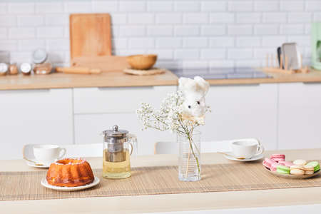 Airy background of cozy kitchen interior with white table and cute accent details, copy space