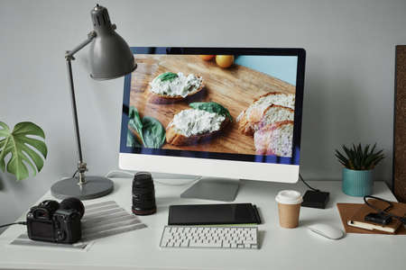 Background image of photographers workplace with computer screen for photo editing, copy spaceの写真素材