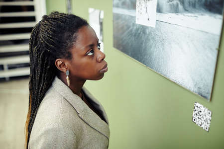 High angle medium close-up of pensive young Black woman with afro braids hairstyle visiting...