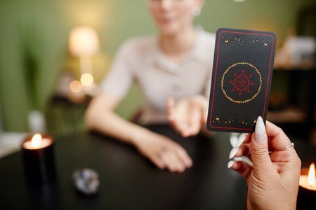 Close up of female fortune teller showing tarot cards for young woman visiting at spiritual seance, copy spaceの写真素材