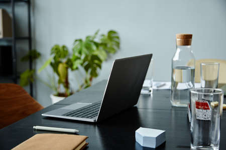 Background image of meeting table with laptop computer and water bottle, copy spaceの写真素材