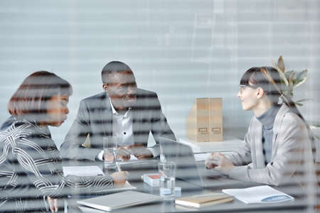 Portrait of black businessman talking to team during meeting in office behind glass wall, copy spaceの写真素材
