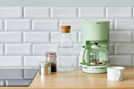 Minimal background image of home coffee station on wooden kitchen counter in morning, copy space