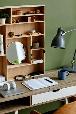 Vertical background image of modern home office workplace with wooden table and notebook set up for studying, copy spaceの写真素材