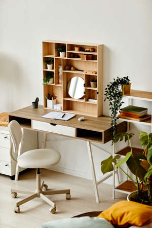 Vertical background image of eco home workplace with wooden table decorated by green houseplants