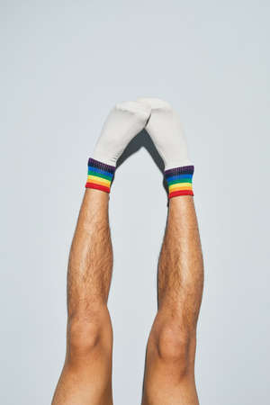 Minimal shot of young man wearing socks with rainbow symbols feet upの写真素材