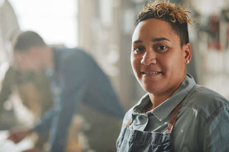 Close up portrait of Latin American female artisan looking at camera in workshop with blurred background, copy spaceの写真素材