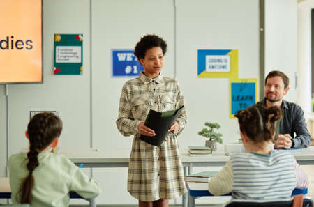 Portrait of young black girl giving presentation in school to group of children, copy spaceの写真素材