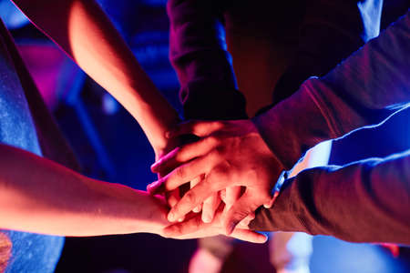 Closeup of eSports gaming team huddling before cybersport competition and stacking handsの写真素材