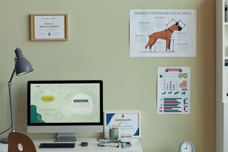 Background image of vet clinic interior, focus on workplace desk with computer and certificates of vet expert on wall, copy spaceの写真素材