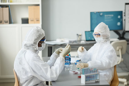 Portrait of young black woman wearing protective gear while working in medical laboratoryの写真素材