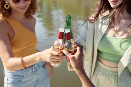 Close up of three young girls clinking bottles while enjoying Summer vacationの写真素材
