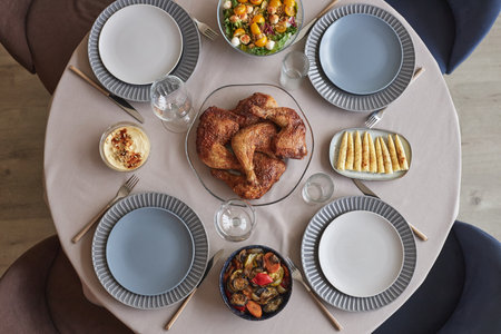 High angle view of table with fried chicken on plate with appetizers and salad serving for holiday...