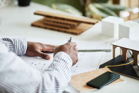 Close-up of architect drawing blueprint at his workplace at officeの写真素材