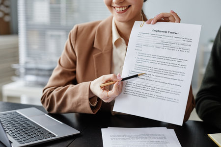 Close up of smiling woman pointing at employment contract in job interview, copy spaceの写真素材