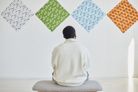Minimal back view shot of man looking at abstract art in museum exhibition, copy sace