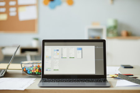 Background image of open laptop with task management setup on screen in creative office interior,...