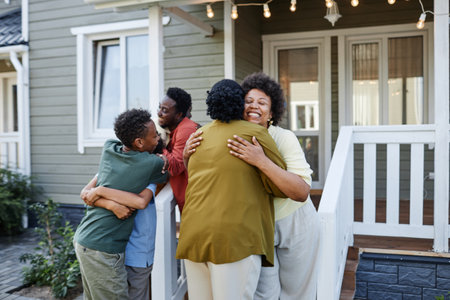 Big African American family embracing outdoors welcoming guests for housewarming partyの写真素材