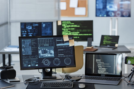 Background image of several computers with data and control panels in IT company office, copy spaceの写真素材