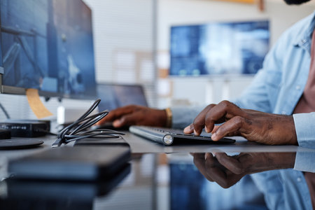 Close up of black man playing shooter video game with focus on hands at keyboard, copy spaceの写真素材