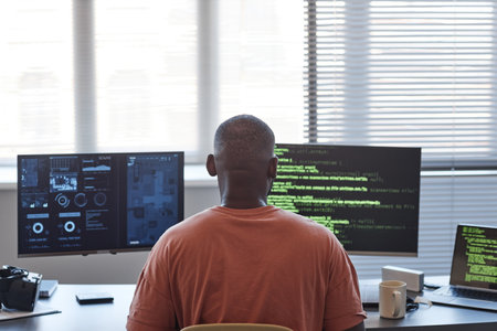 Back view of African American man using computers with data and code lines in office, copy spaceの写真素材