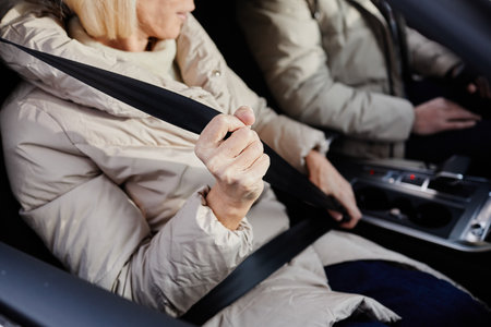 Close up of mature woman fastening seat belt in car, copy spaceの写真素材