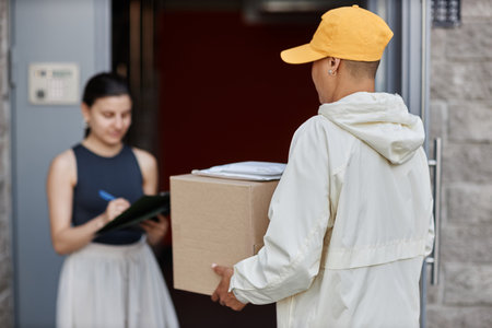 Back view of delivery person holding box while waiting for client signing documents, copy space