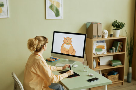 Desktop computer with fat ginger cat drawn by young creative digital artist on screen during work...