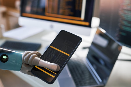 Closeup image of software developer holding smartphone with prosthetic arm