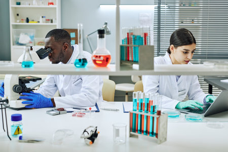 Portrait of two ethnic scientists working in laboratory and doing medical researchの写真素材