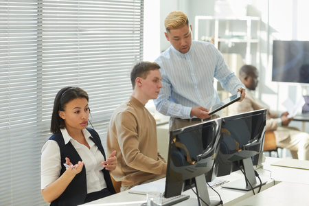 Diverse group of people working in call center focus on black young woman wearing headset and...