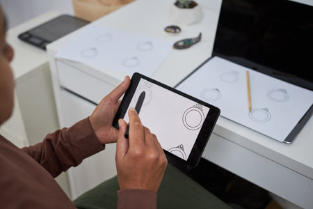 Close up of female artist using pen tablet creating new jewelry designs, copy space