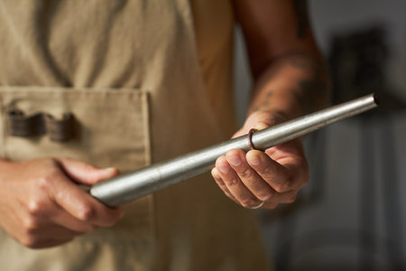 Close up of artisanal jeweler fitting ring size in workshop, copy spaceの写真素材